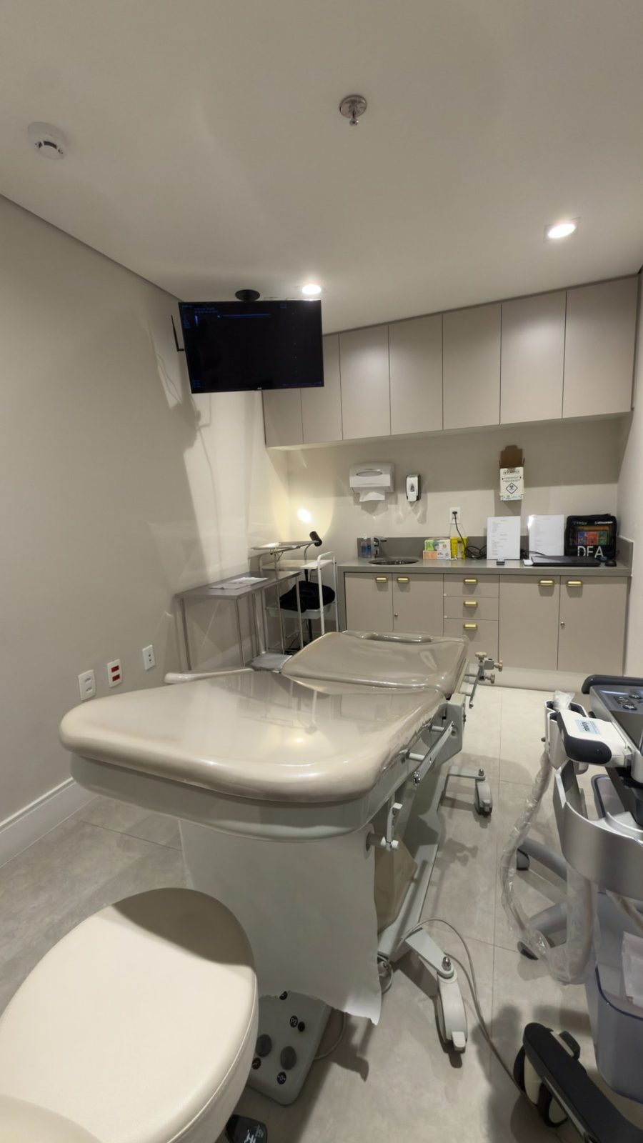 Sala de ablação com monitor espelhado do ultrassom, bancada e desfibrilador